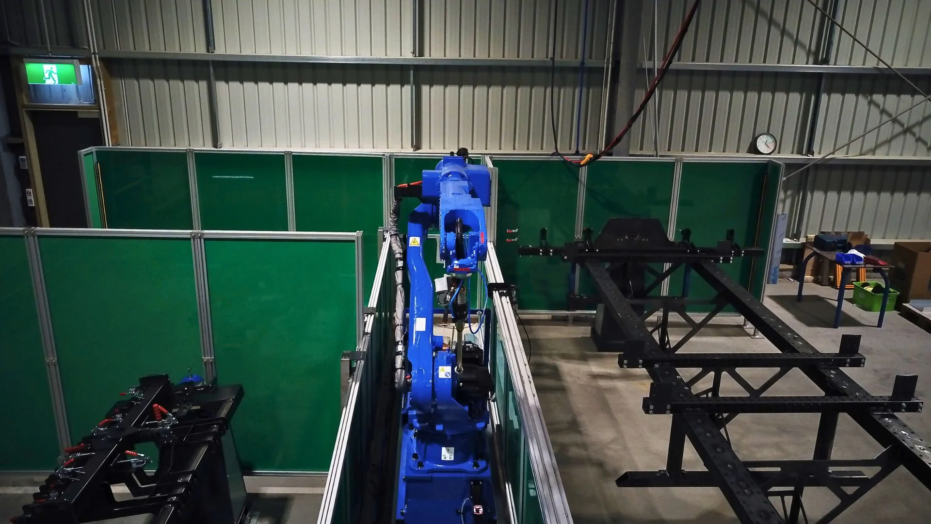 Robot welding cell featuring an industrial robot on a slider.